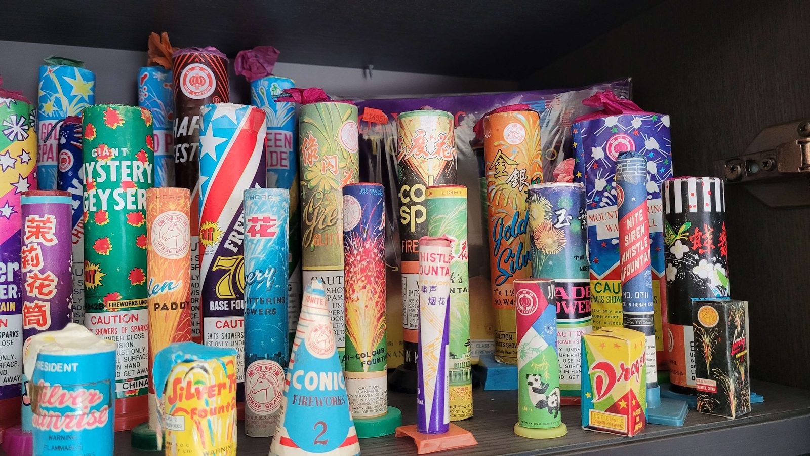 A row of vintage California Safe and Sane fireworks including Horse Brand, Mystery Geyser, and original Chinese-import fountains
